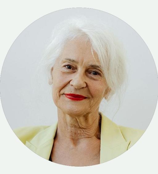 Portrait einer älteren Dame mit rotem Lippenstift lächelt freundlich in die Kamera