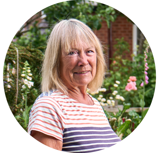 Frau steht vor einem Blumenbeet