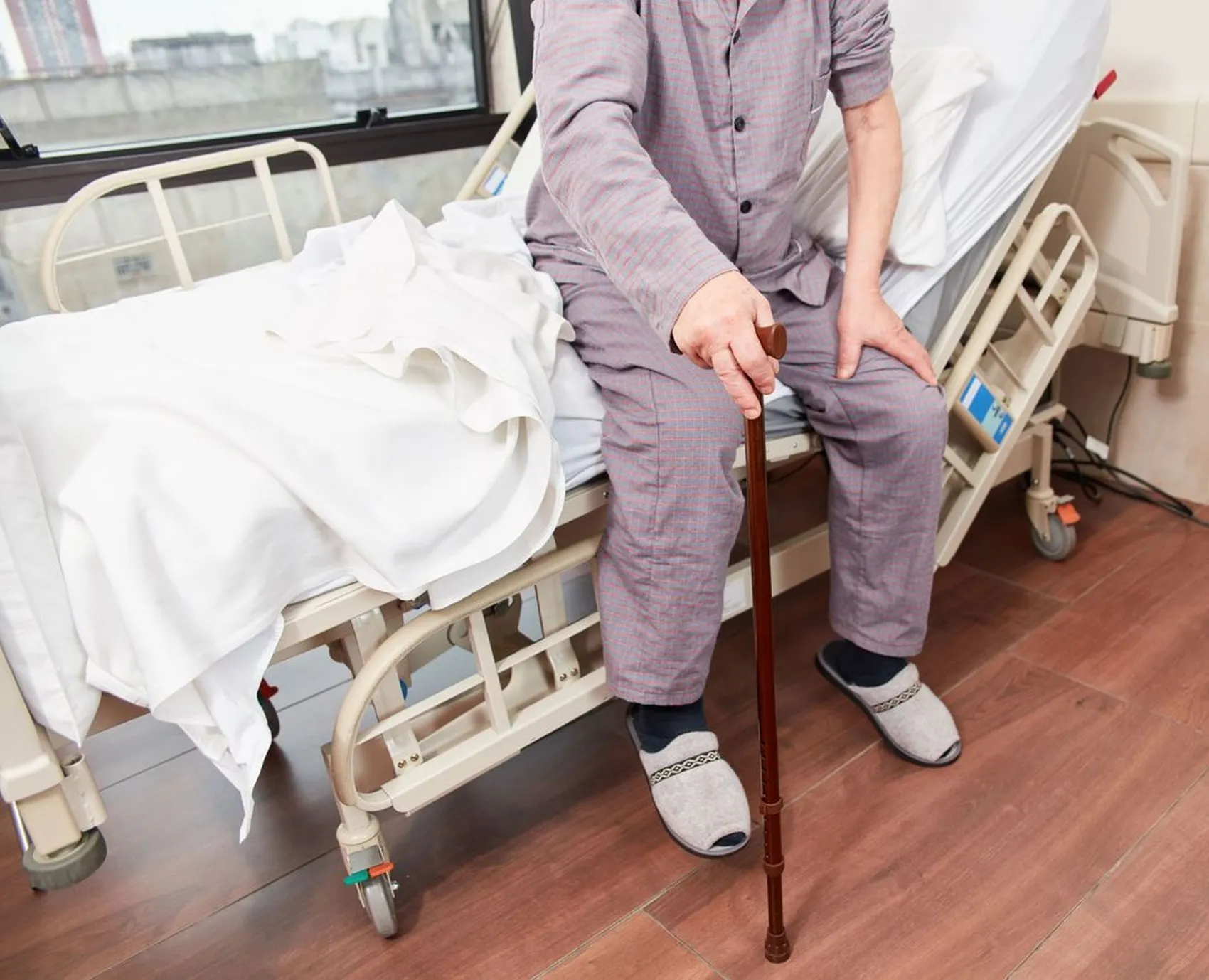 Mann sitzt auf Krankenhausbett