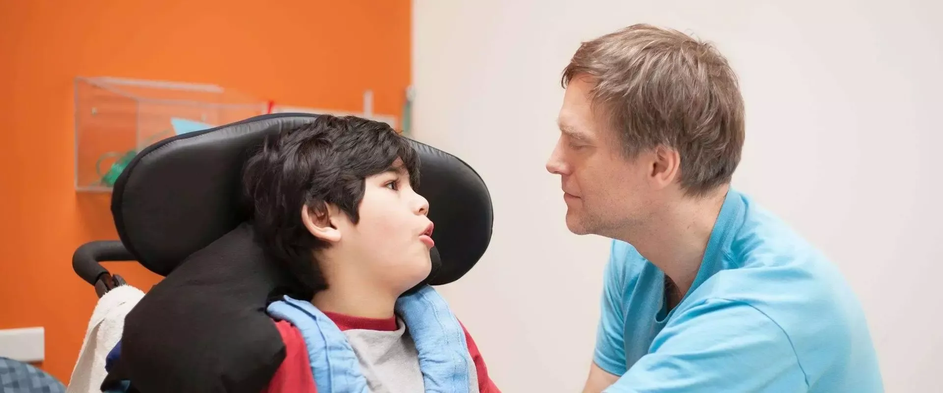 Vater spricht mit Sohn im Rollstuhl