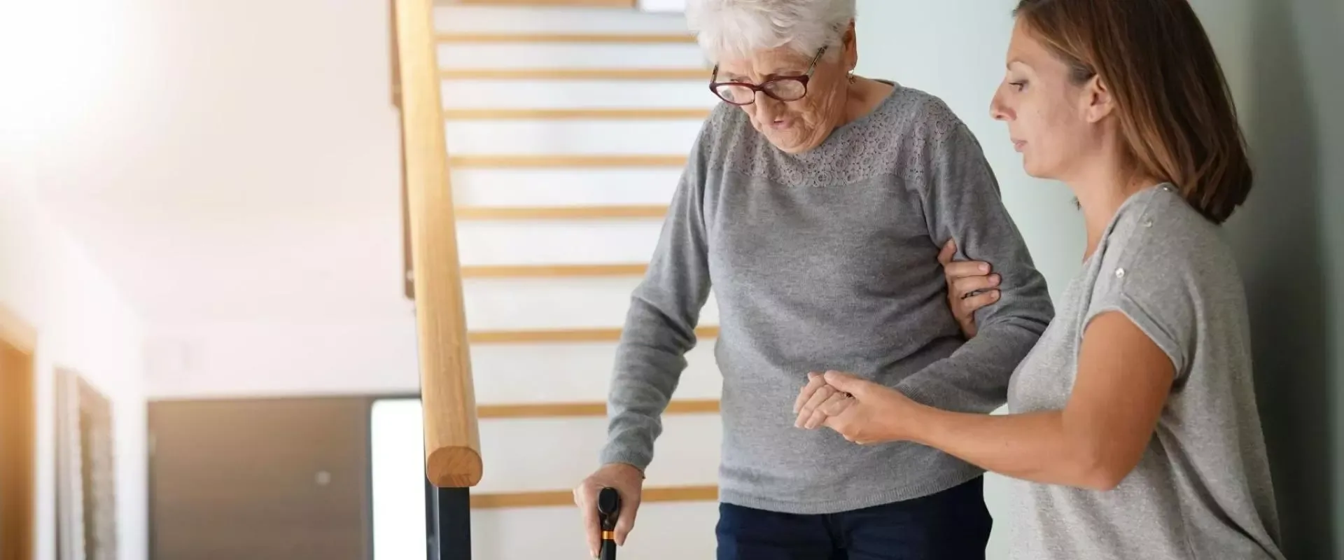 Bild Frau hilft Oma beim Treppengang