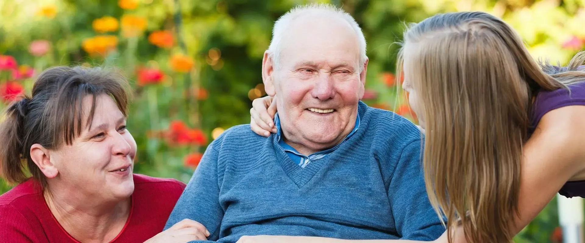 Mann im Rollstuhl wird von einer jüngeren Frau begrüßt