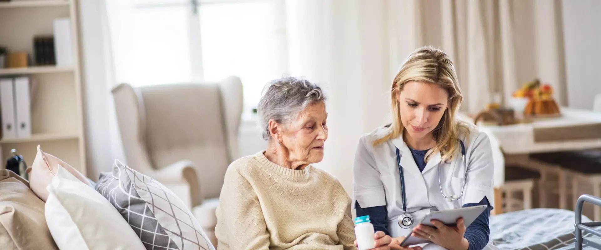 Pflegekraft bespricht Medikationsplan mit Heimbewohnerin