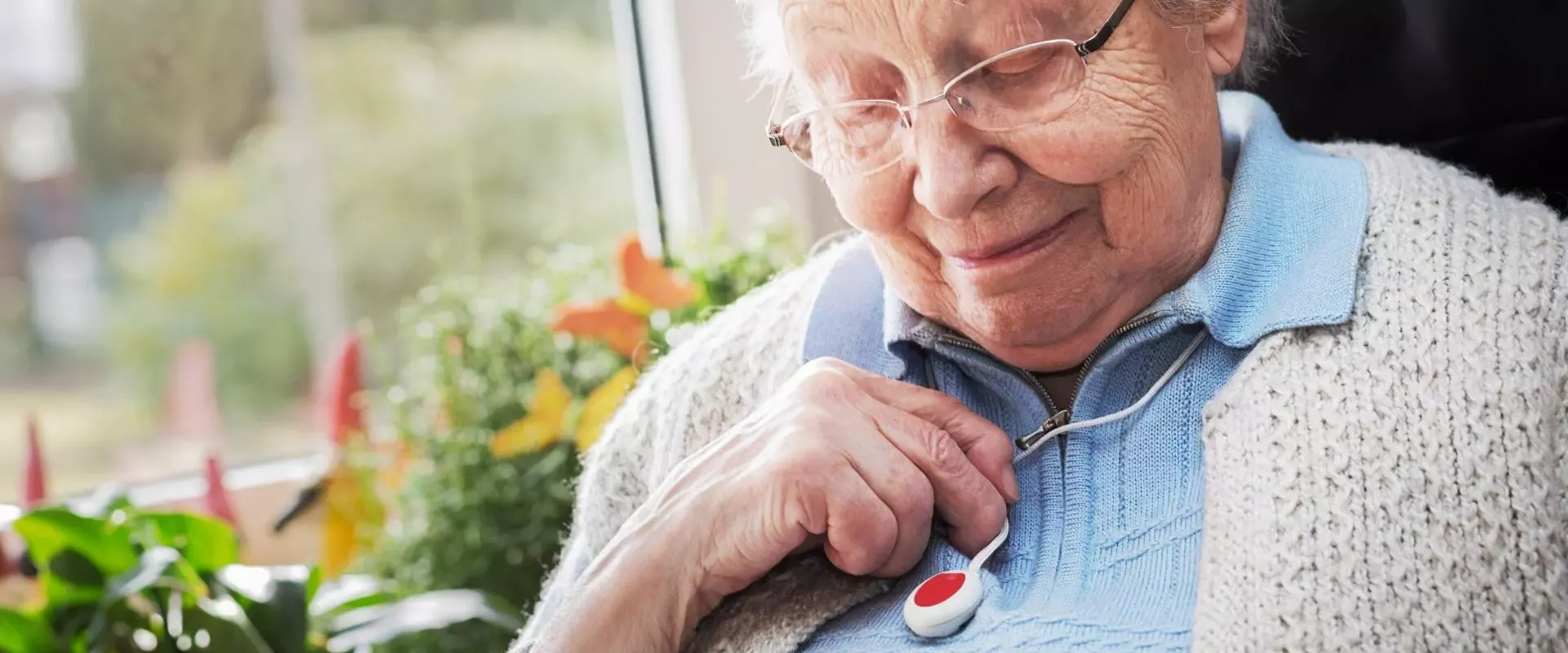 Frau trägt einen Hausnotrufknopf um den Hals