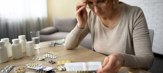 Bild Frau am Tisch mit Medikamenten