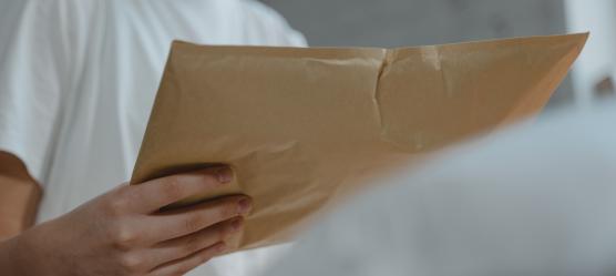 Frauenhand hält Briefumschlag