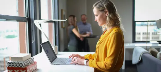 Frau steht am Laptop