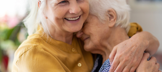 Bild: Frau umarmt Seniorin