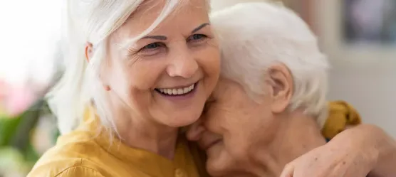 Bild: Frau umarmt Seniorin